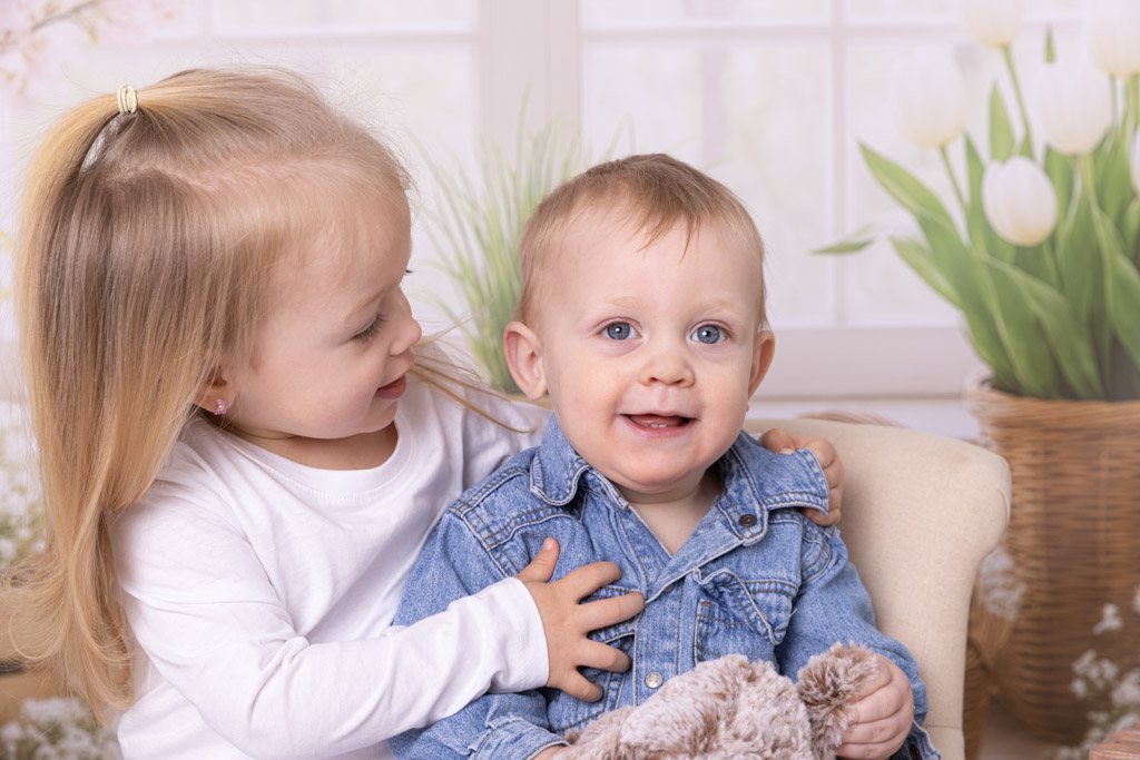 zwei kinder in meinem Osterset, beide sitzen lachend auf einem Stuhl