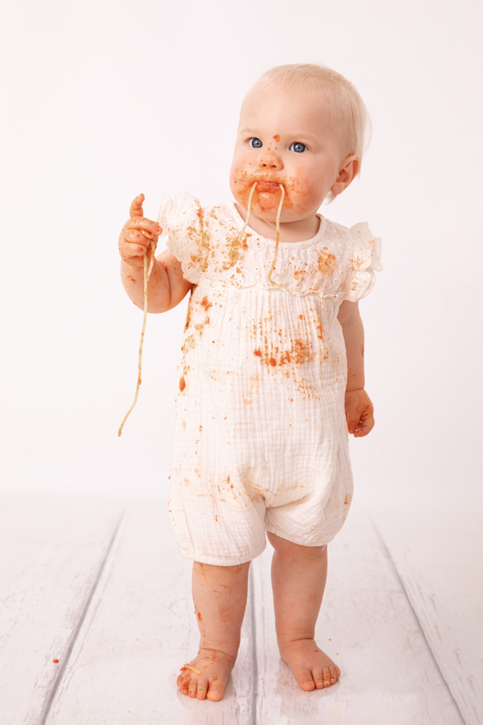 Kind mit Spaghetti im Mund