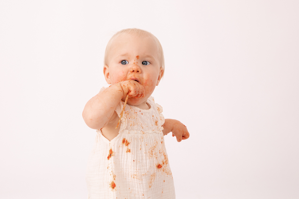 Kind mit Spaghetti im Mund und es schmeckt sichtlich