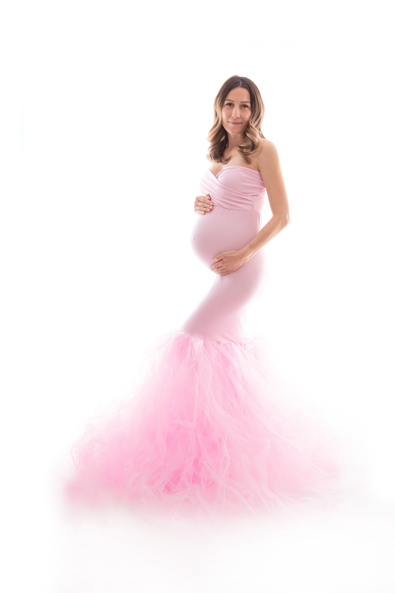 Schwangere in einem rosa kleid mit einem Tüllrock. Babybauchshooting Carina Rosen