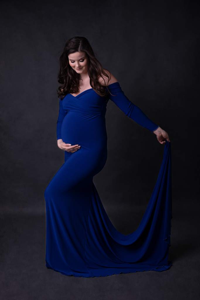 Schwangere im blauem Kleid vor dunklem Hintergrund in Lohmar von Fotografie Carina Rosen