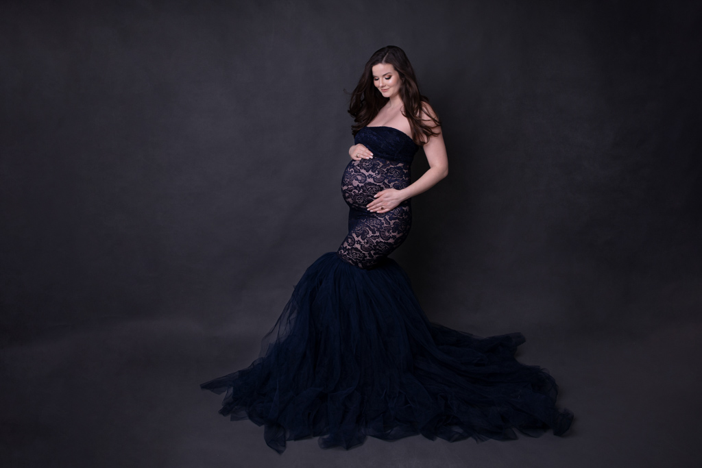 Schwangere im dunkel blauem Tüll-Kleid vor dunklem Hintergrund in Lohmar von Fotografie Carina Rosen